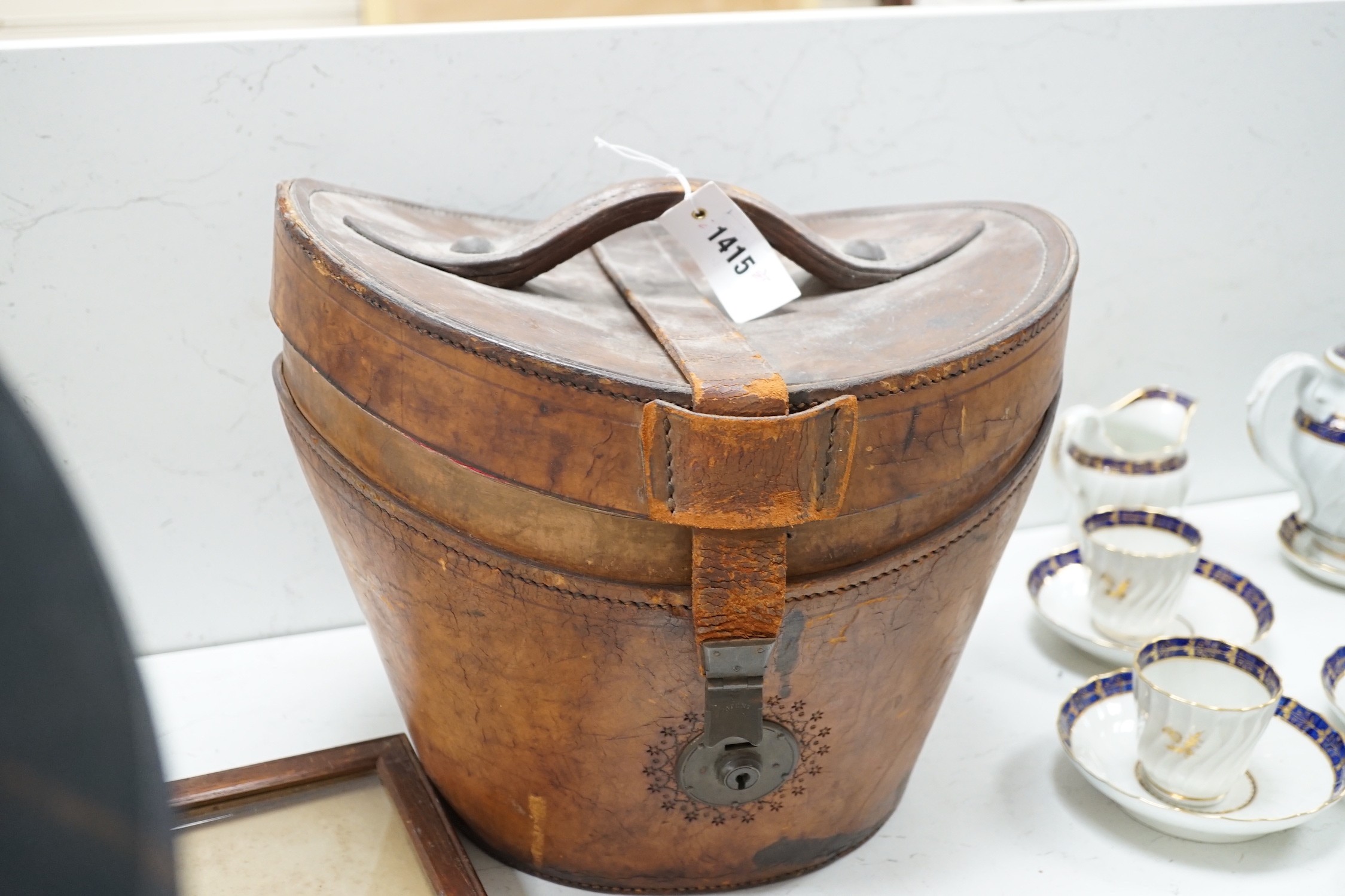 A Victorian top hat and kid gloves, leather cased